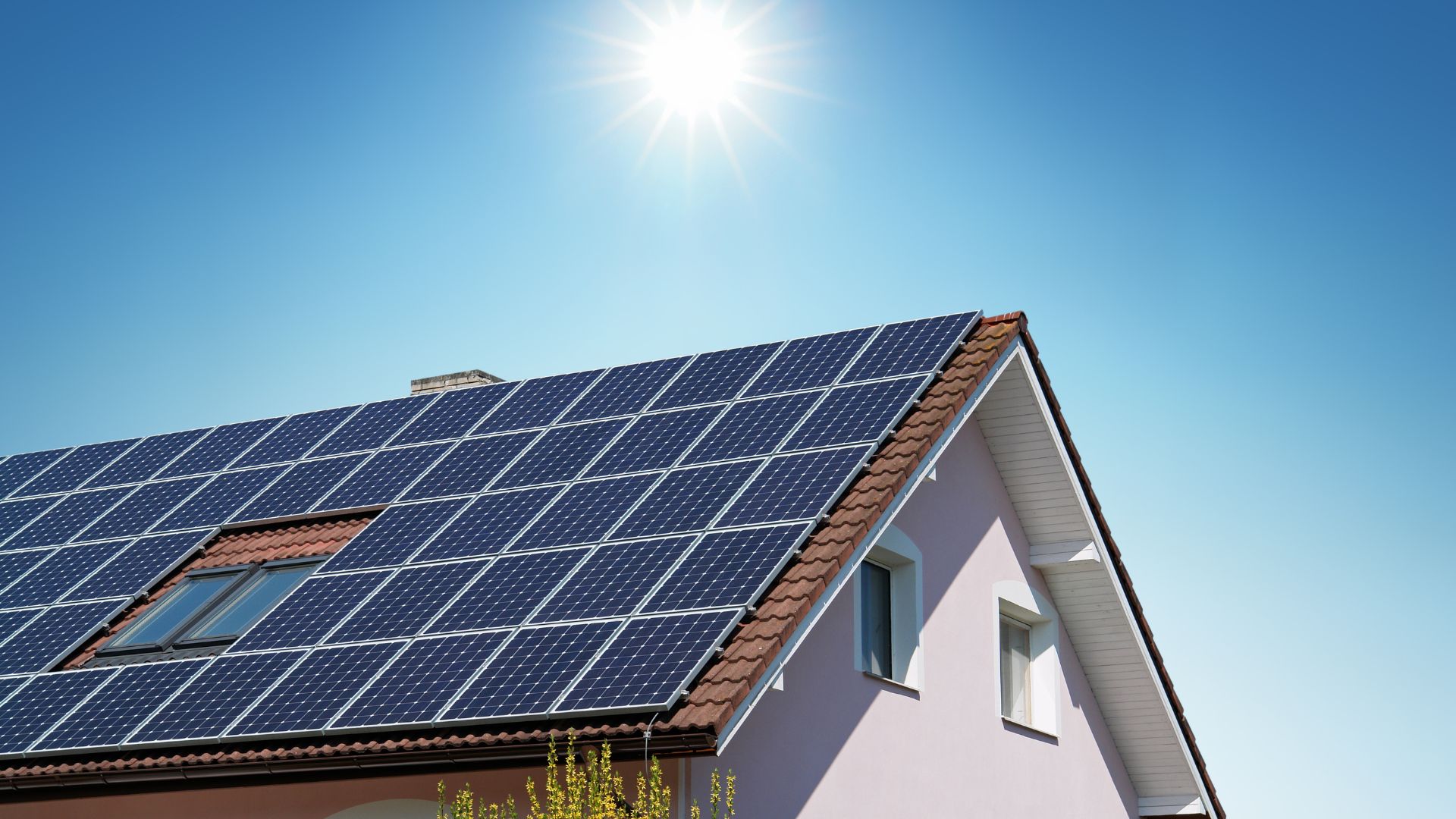 Solar panels on residential roof under bright sunny blue sky