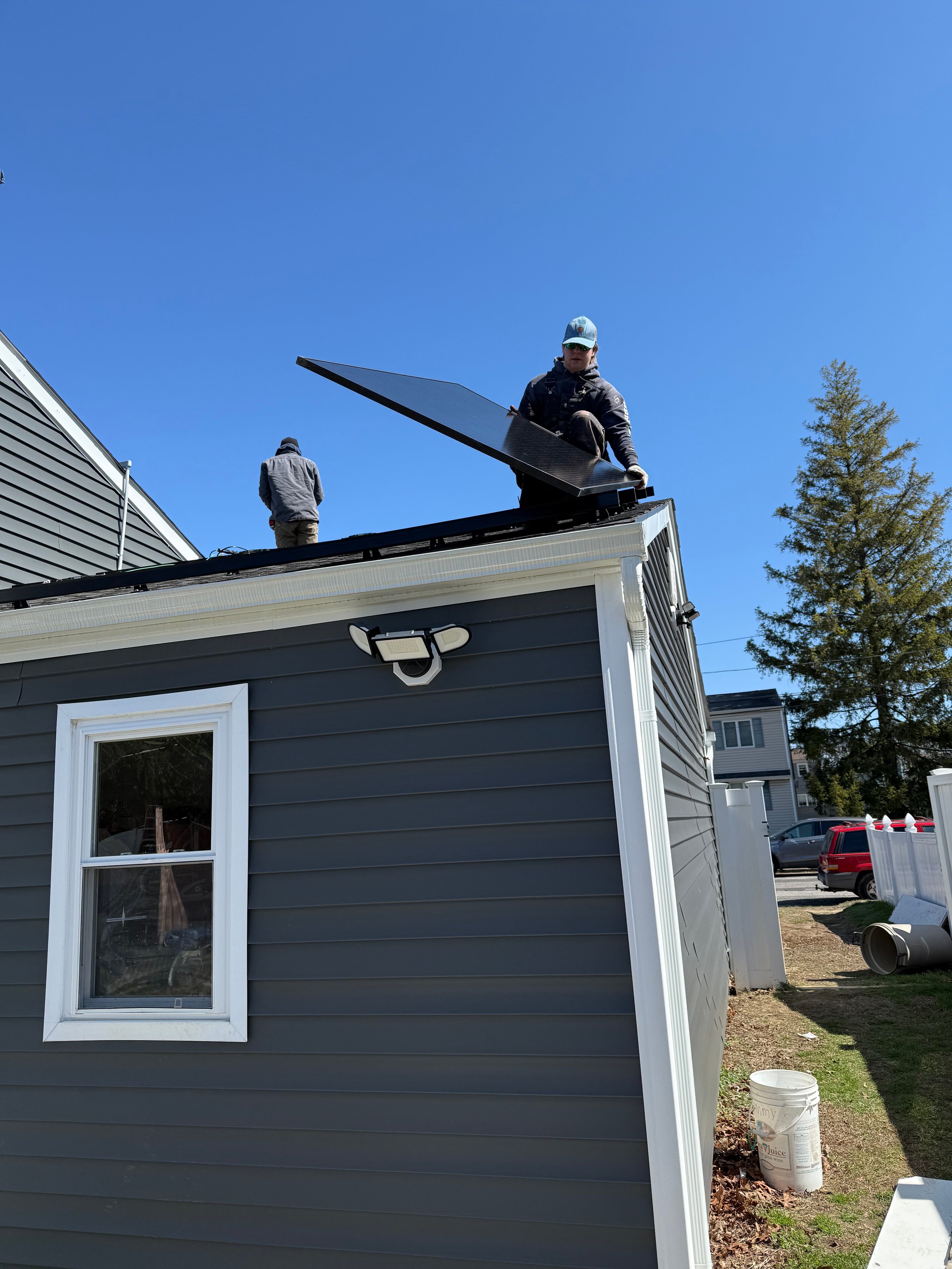 Workers installing solar panels on a residential house roof