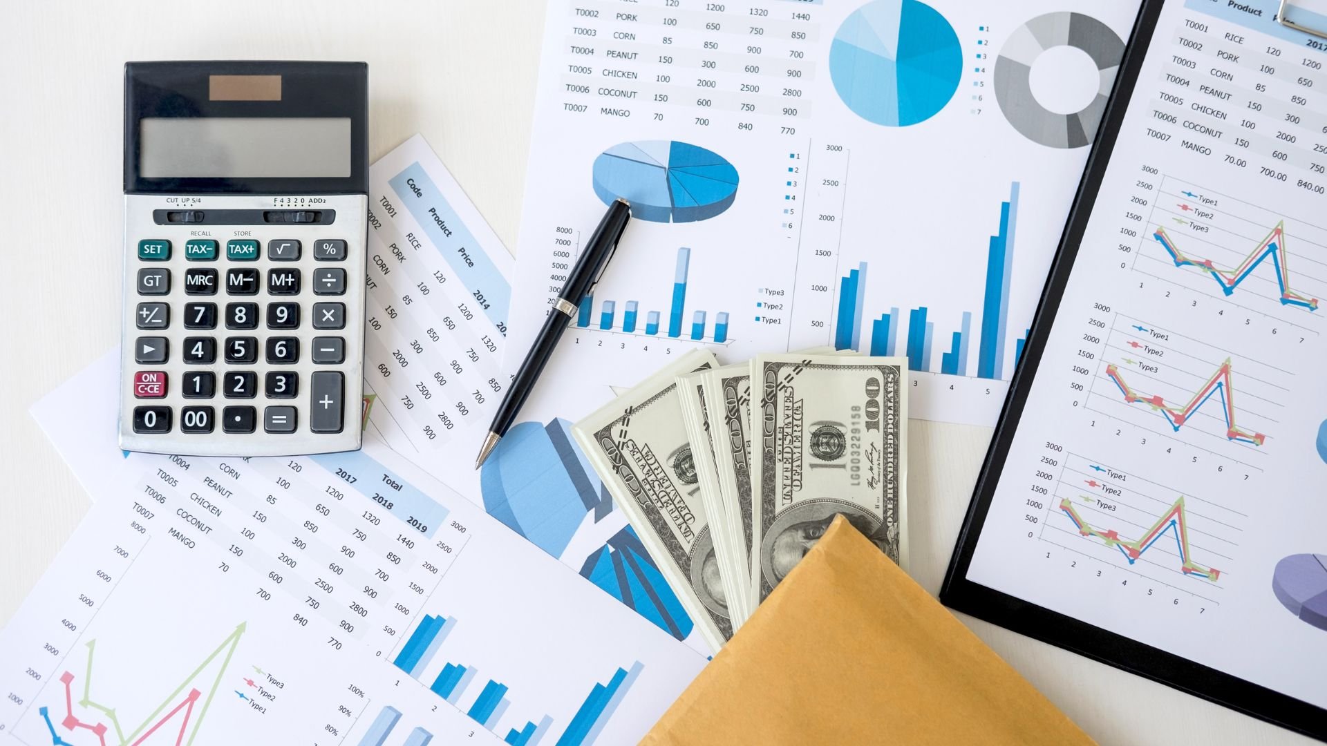 Financial documents, calculator, money, and charts showing business analytics